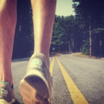 Feet of an athlete running on a deserted road – Training for fit