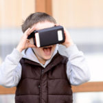 Fascinated little boy  using VR virtual reality goggles